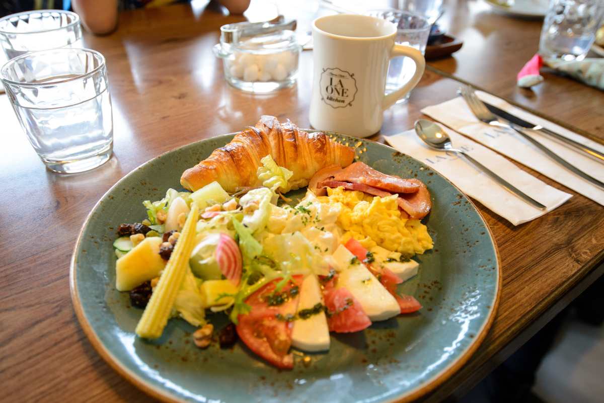 Croissant with Tomato, Mozzarella, Ham, Scrambled Eggs, Potatos and Salad