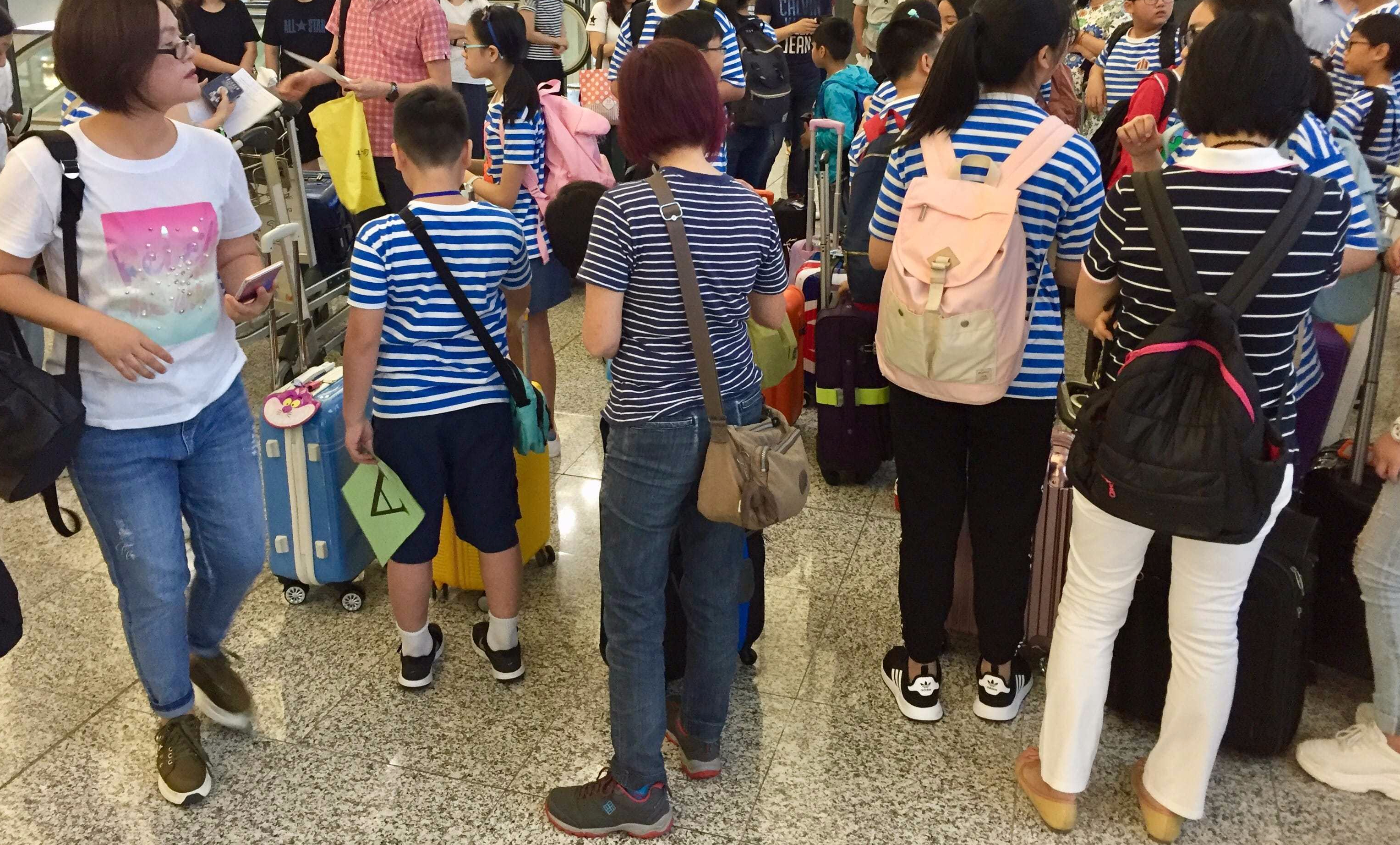 Happy boys and girls assembled at the departure hall